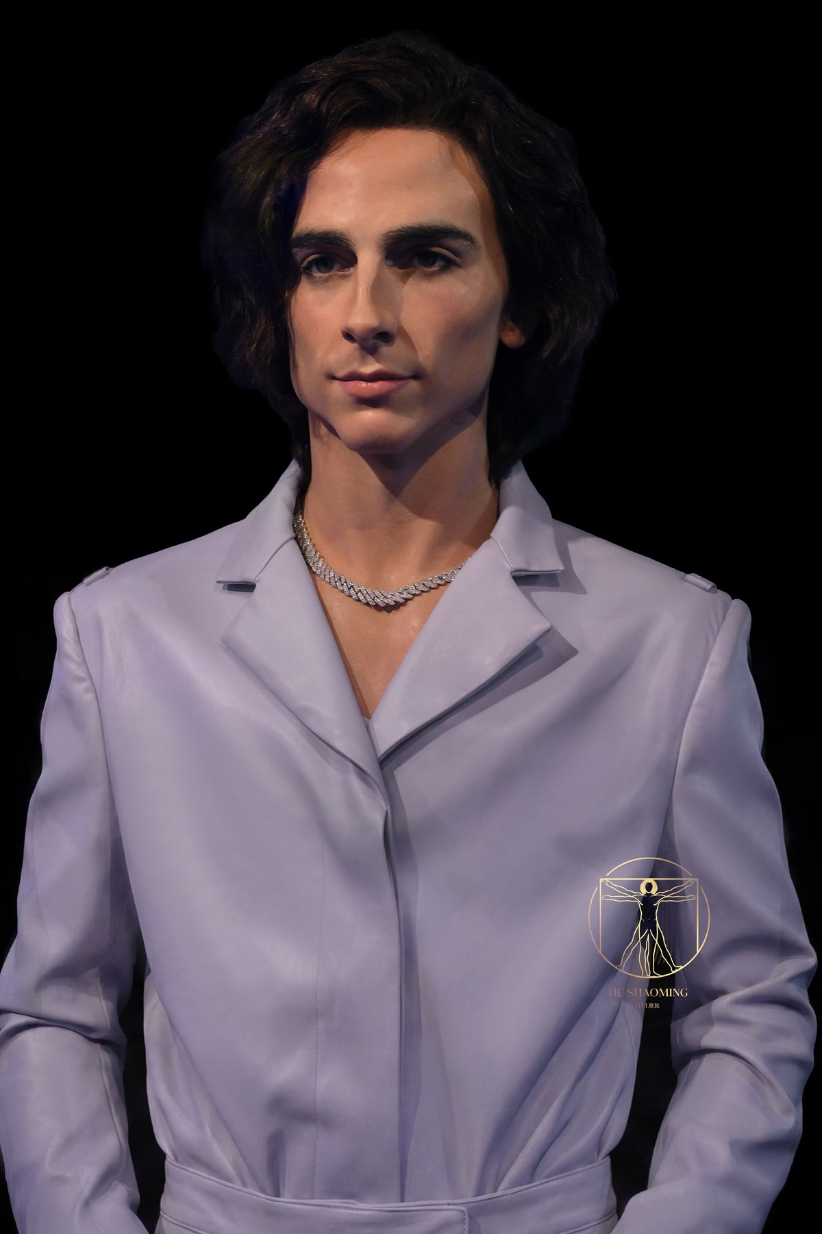 Lifelike silicone bust of Timothée Chalamet wearing a white leather suit and chain necklace